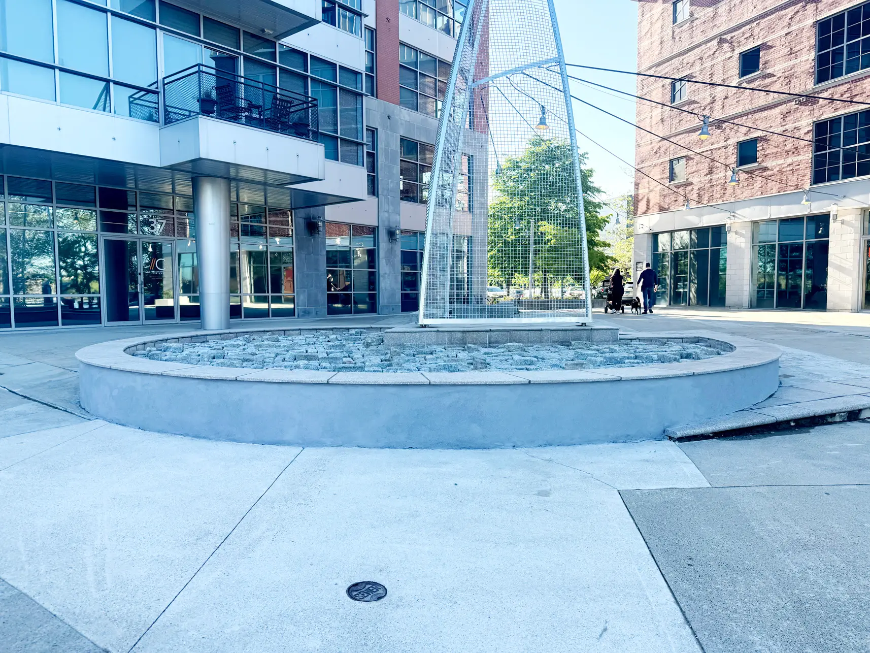Curved granite-capped seat wall and cobblestone bed at a commercial plaza in Norwalk, CT